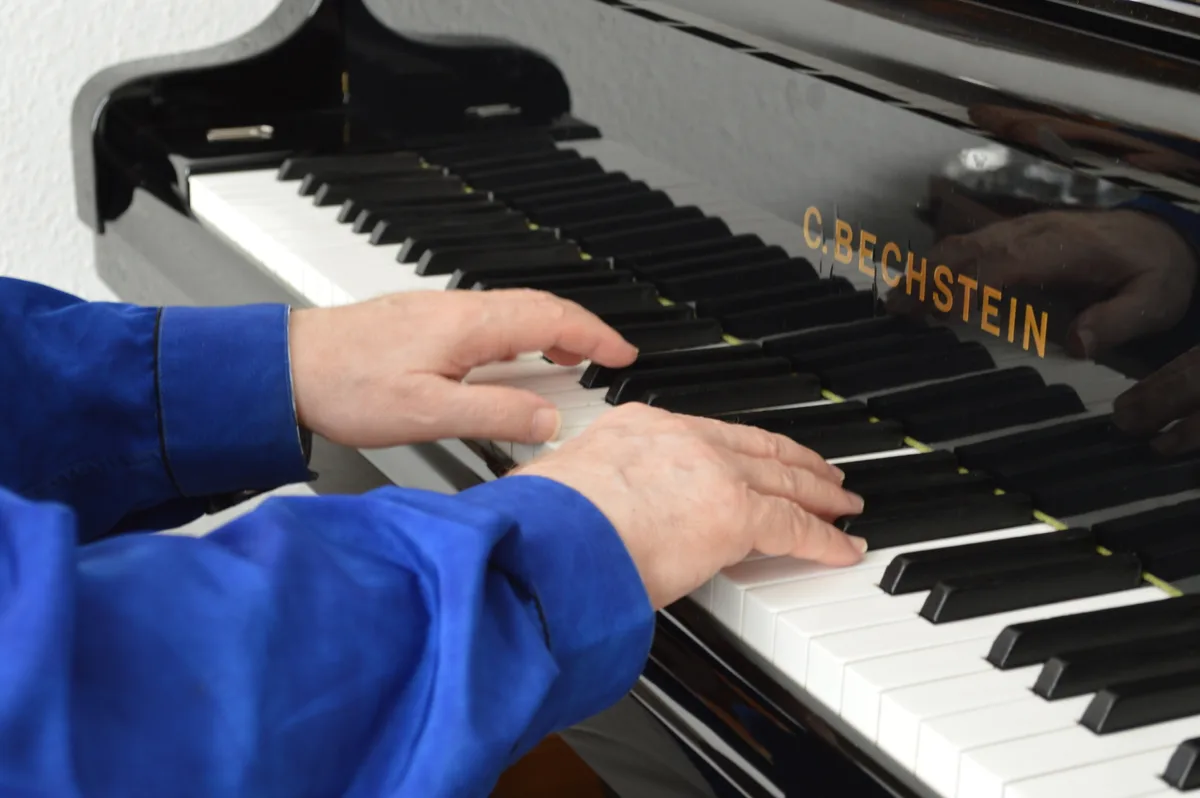 Hände gleiten über Klaviertasten.